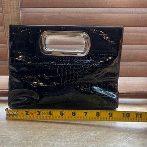 Like new used once black patten leather clutch with button closure